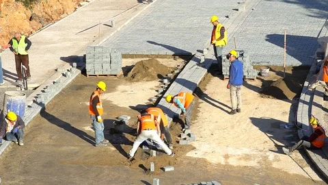 Construction workers pour concrete mix from cement mixer and trowel flat Vidéo 87807364