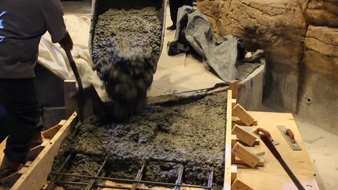Construction workers pour freshly mixed concrete into wood and rebar mold 스톡 동영상 114924972