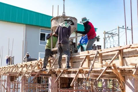 Construction Workers Pouring Concrete into Formwork. Stock Photos