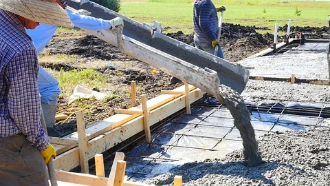 Construction workers pouring concrete foundation Stock Footage 98222194