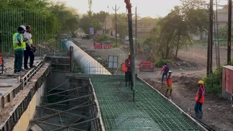 Construction Workers Pouring Concrete Foundation with Pump at Sunset 4K Video Stock Footage 336942725