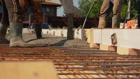 Construction workers pouring concrete foundation for a house Stock Footage 341294359