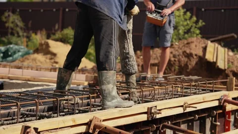 Construction workers pouring concrete foundation for a house Stock Footage 341294522