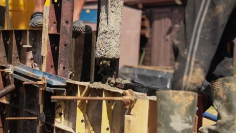 Construction workers pouring concrete into foundation formwork Stock Footage 341294712