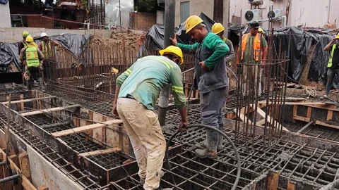 Construction workers pouring concrete into reinforced foundation using machinery Stock Footage 328308028