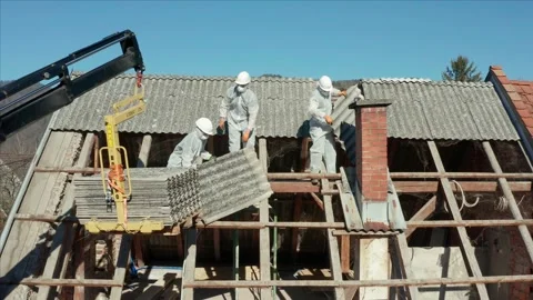 Construction Workers In PPE And Hard Hats Dismantling Roof Tiles Of A Stock Footage 162045886