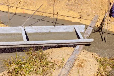 Construction workers prepare pour concrete into forms at building site during Foto stock