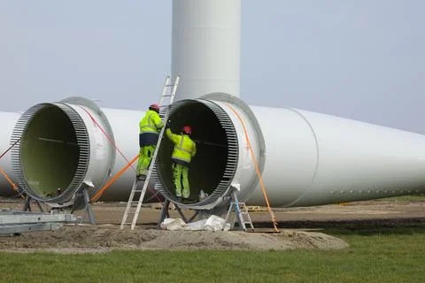 Construction workers preparing the rotor blades of a new wind turbine. Foto stock