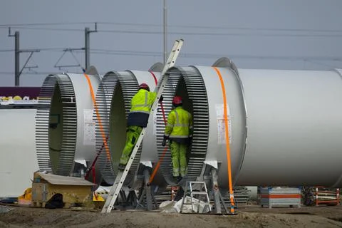 Construction workers preparing the rotor blades of a new wind turbine. Stock Photos