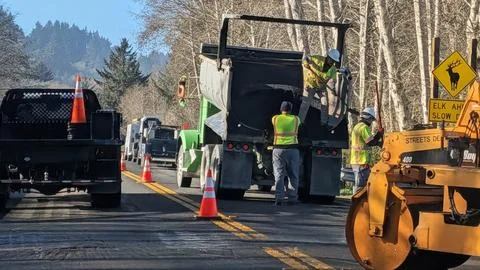 Construction workers in reflective vests shovel Stock Photos