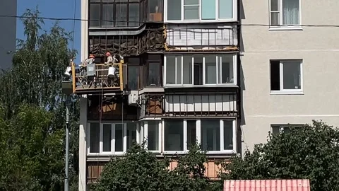 Construction workers renovating apartment building facade from elevated pla.. Stock Footage 344456704