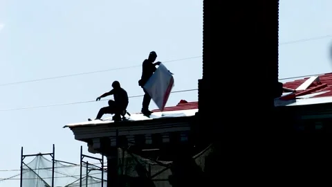 Construction workers repairing red metal roof. Russia - 22 September 2026 Stock Footage 341833363