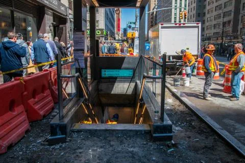 Construction workers replacing the sidewalk around the entrance to the F trai Stock Photos