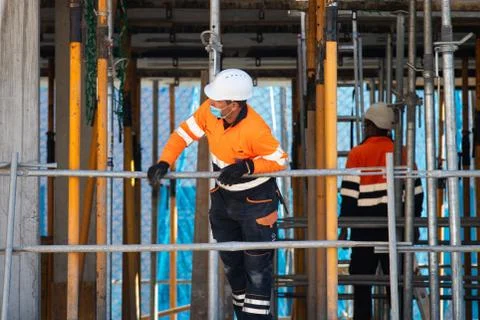 Construction workers return to work with masks protected against Covid-19. Stock Photos