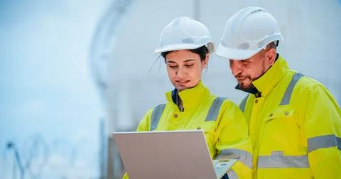 Construction workers review plans at a construction site during daylight hour Stock Photos