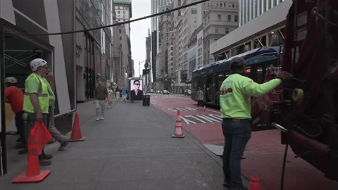 Construction workers roll a debris bin from a garbage truck on a Fifth Ave Stock Footage 341011917