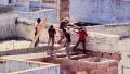 Construction workers on the rooftops of the old blue city of Jodhpur HD Footage