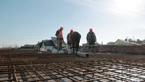 Construction workers in safety vests and helmets working with rebar and concrete Stock Footage 306407147