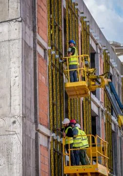Construction workers on a scaffold. Men working at a buildingfrom a hydraulic Stock-Fotos