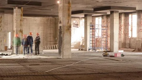 Construction workers with scaffolding and tools inside the floor of high risi Foto stock