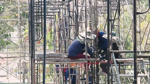 Construction workers on scaffolding in a building site. Stock Footage 147669925