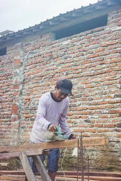 Construction workers shaving wood with machine for foundry Stock Photos