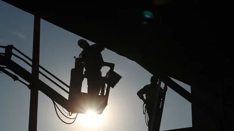 Construction Workers Silhouetted Against The Sun Stock Footage 47057512