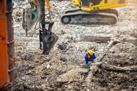 Construction workers sitting among the rubble of demolished buildings with wo 스톡 사진