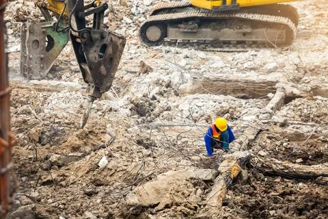 Construction workers sitting among the rubble of demolished buildings with wo Stock-Fotos