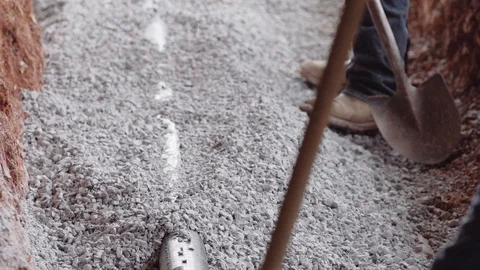 Construction Workers Spread Gravel Out Inside A Trench 스톡 동영상 87482775