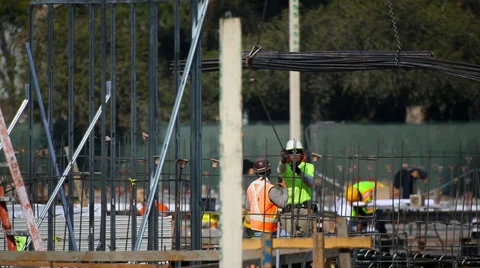 Construction workers take the load from the crane at development site Stock Footage 34520054