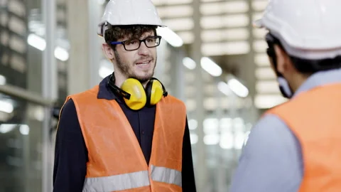 Construction workers talking to colleagues in a machinery factory. Coordination  Stock-Footage 157276170