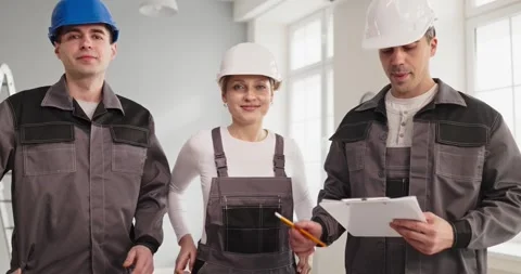 Construction workers team portrait in hard hats, planning renovation indoors Stock Footage 332802884
