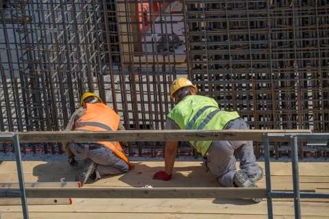 Construction workers tying rebar to make reinforcing frame 2 Stock Photos