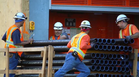 Construction workers unload pipes at development site Stock Footage 34135163