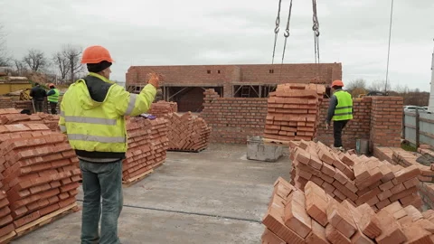 Construction workers unloading bricks on site, A group of construction workers Stock Footage 304214361