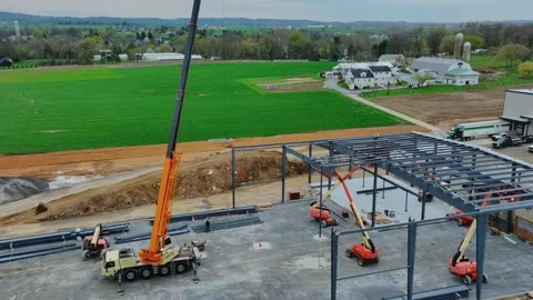 Construction Workers Use a Crane to Build a Structure in a Rural Area Durin.. Video stock 329775957