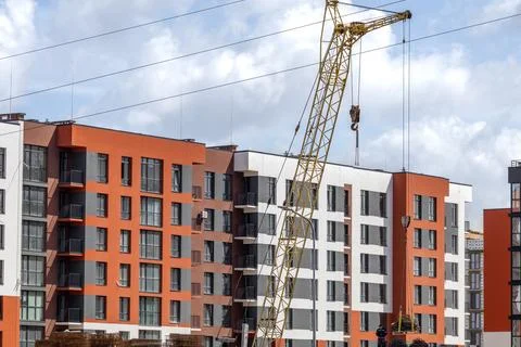 Construction Workers Use a Crane to Lift Materials at a Building Site in a .. Stock Photos
