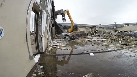 Construction workers use heavy equipment to tear down building at demolition Video stock 125055704