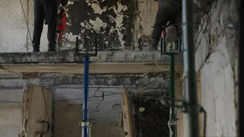 Construction workers use jackhammers to dismantle damaged ceilings, walls in Stock Footage 281411256