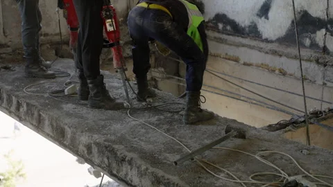Construction workers use jackhammers to dismantle damaged ceilings, walls in Stock Footage 292435031