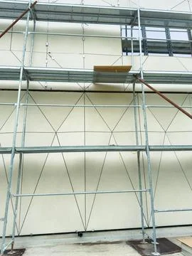Construction workers use scaffolding to support their work on a building in.. Stock Photos
