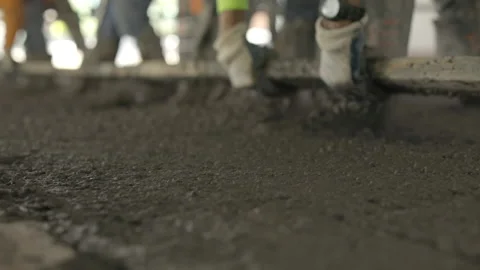 Construction workers use a screed on poured concrete in an office building. Stock Footage 144458366