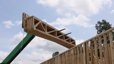 Construction workers use telehandler crane to lift wooden beams into place in Stock Footage 320745691