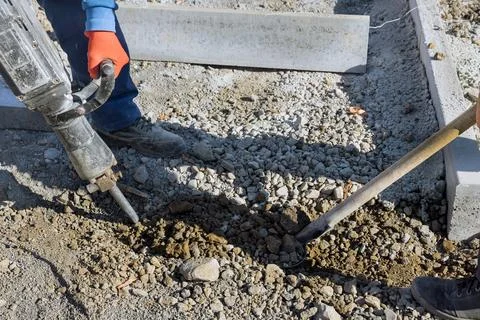 Construction workers using a jackhammer to dig out the concrete surface on the Stock Photos