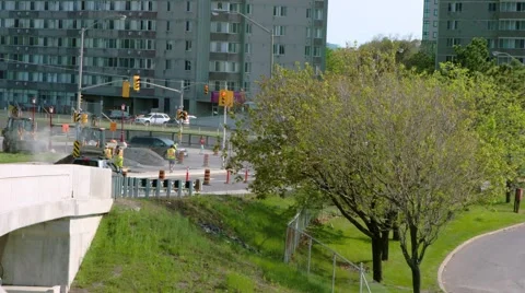Construction workers using two backhoes as traffic passes in foreground. Stock Footage 67422876