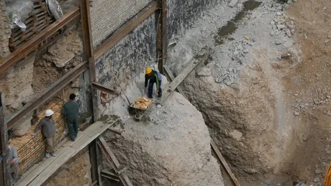 Construction workers using wheelbarrows to carry bricks in dangerous unsafe way Stock Footage 96131436