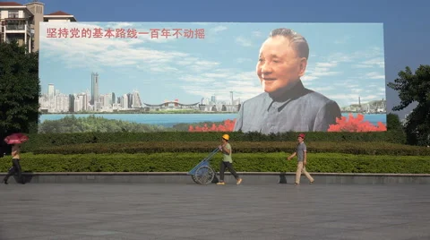 Construction workers walk past Deng Xiaoping billboard in Shenzhen, China Stock Footage 61865532