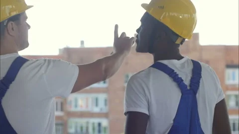 Construction workers walking on building site and discussing Vídeos de archivo 119608470