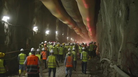 Construction workers walking into a large tunnel Stock-Footage 92184478